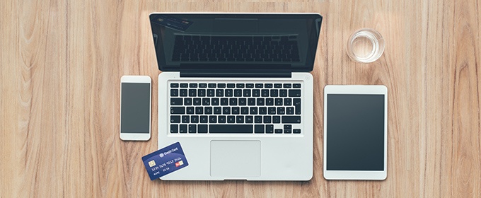 Laptop, telefoon, tablet en creditcard op tafel