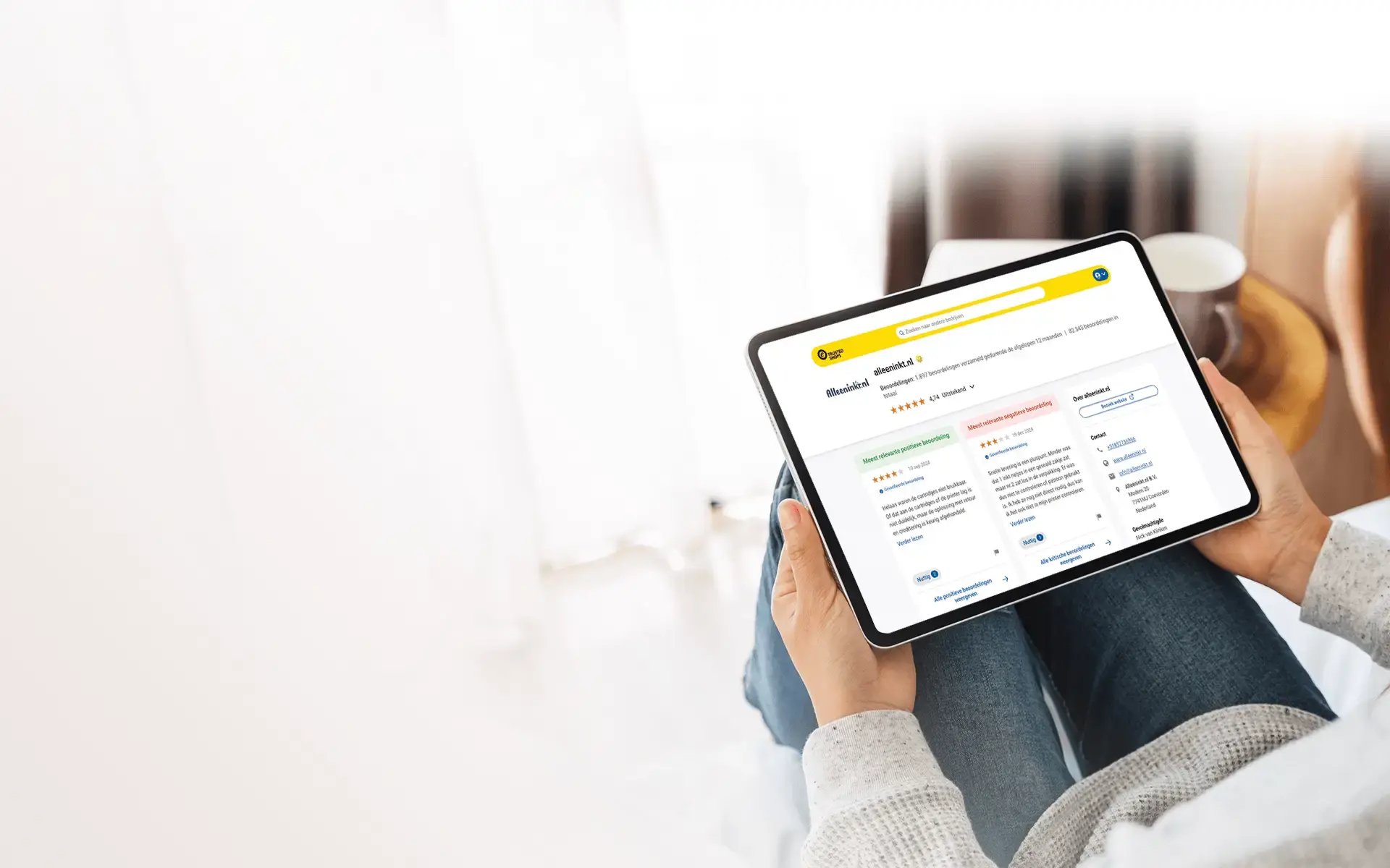 Iemand heeft en tablet op schoot met daarop het Trusted Shops bedrijfsprofiel van Alleeninkt