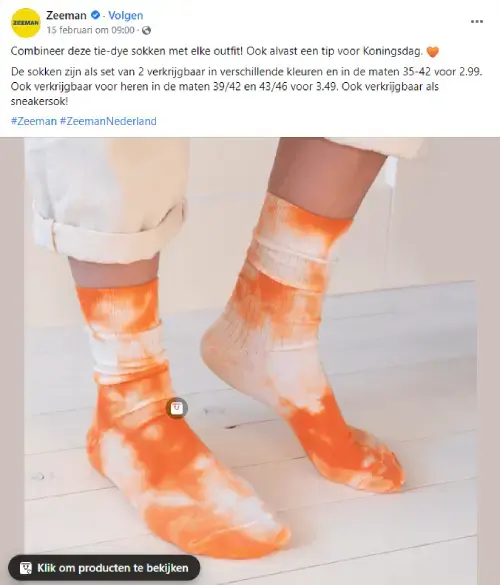 Close-up van voeten met oranje tie-dye sokken van Zeeman, gedragen op lichte houten vloer. Beeld uit Facebookpost met Koningsdag-tip: opvallende oranje sokken als feestelijke accessoire voor Koningsdag-outfits.