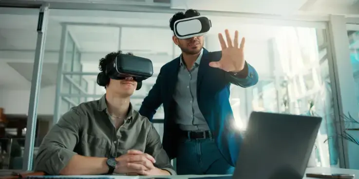Demonstratie van AR- en VR-technologie in een kantooromgeving, waarbij twee personen met VR-brillen een digitale ervaring testen bij een laptop. Illustratie van hoe immersive technologie kan worden ingezet voor webshops en productbeleving.