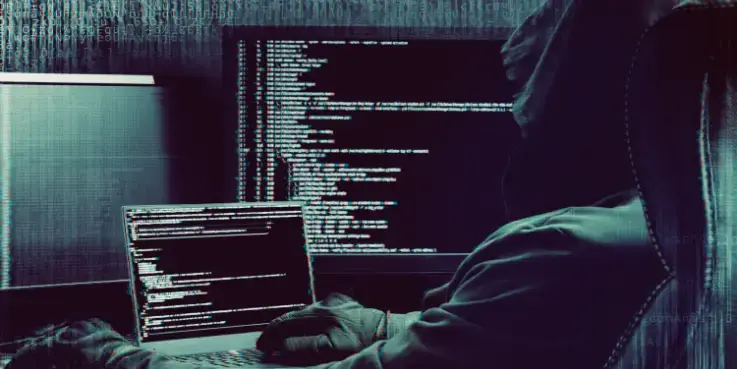 Een schimmig figuur zit op de computer op het darknet te browsen