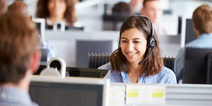 Een vrouw zit in een contact center het perfecte telefoongesprek te voeren