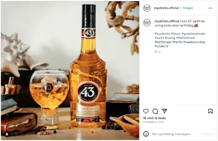 Instagram-post van het account topdrinks.official met een fles Licor 43 en een glas met ijs op een houten tafel, omringd door herfstdecoratie zoals kaneelstokjes en kruiden. Warme herfstsfeer, passend bij likeur, herfstdrankjes en seizoensmarketing.