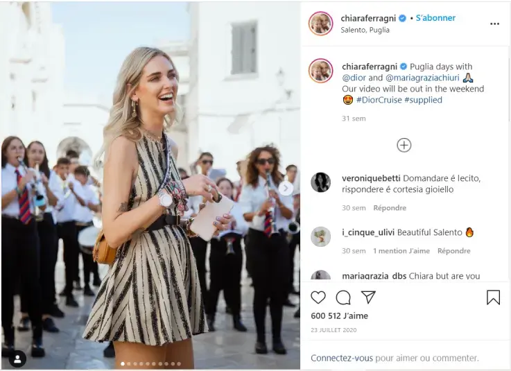Instagram‑post van influencer Chiara Ferragni tijdens een buiten­evenement in Italië, met publiek en muzikanten op de achtergrond. De post toont een gesponsorde samenwerking met een luxe modemerk en illustreert influencer marketing en media impact value.