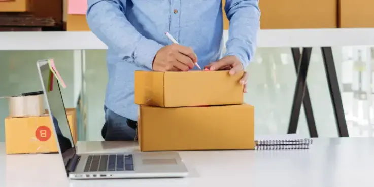 Een webwinkelier pakt een bestelling in. In Duitsland geldt de Verpackungsgesetz