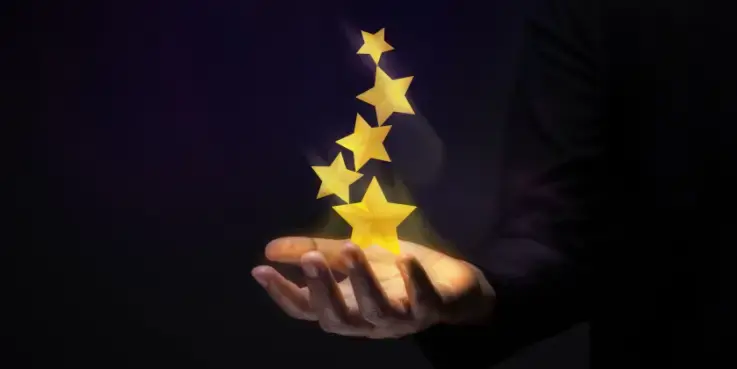 Een foto van een hand waar sterren boven zweven als symbool voor beoordelingen beantwoorden
