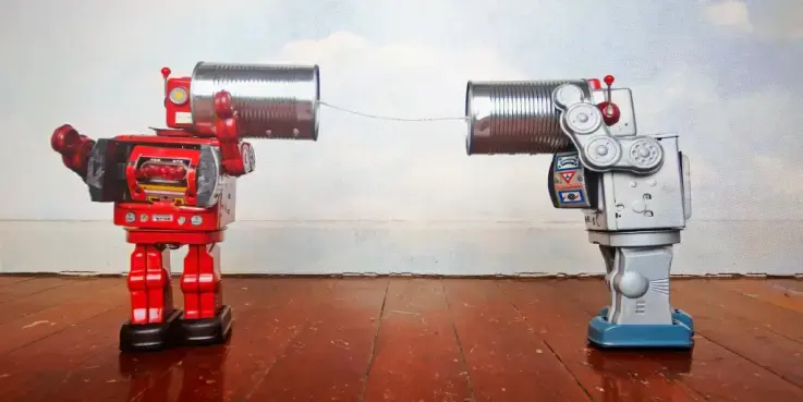 Twee retro speelgoedrobots verbonden met een bliktelefoon, symbool voor communicatie en vertrouwen in het AI-tijdperk. Beeld over automatisering, chatbots en hoe webshops geloofwaardigheid en authenticiteit behouden met AI.