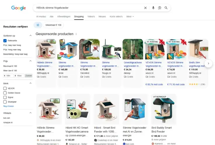 Screenshot van Google Shopping-resultaten voor 'HiBirds slimme vogelvoeder' met gesponsorde en organische producten. Te zien zijn slimme vogelvoeders met camera, prijzen, webshops, filters en aanbiedingen binnen het tabblad Shopping van Google. 
